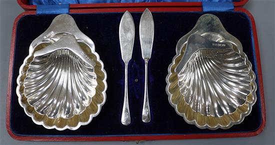 A cased pair of Edwardian silver butter shells, James Deakin & Sons, Sheffield, 1907, with associated knives and one other pair.